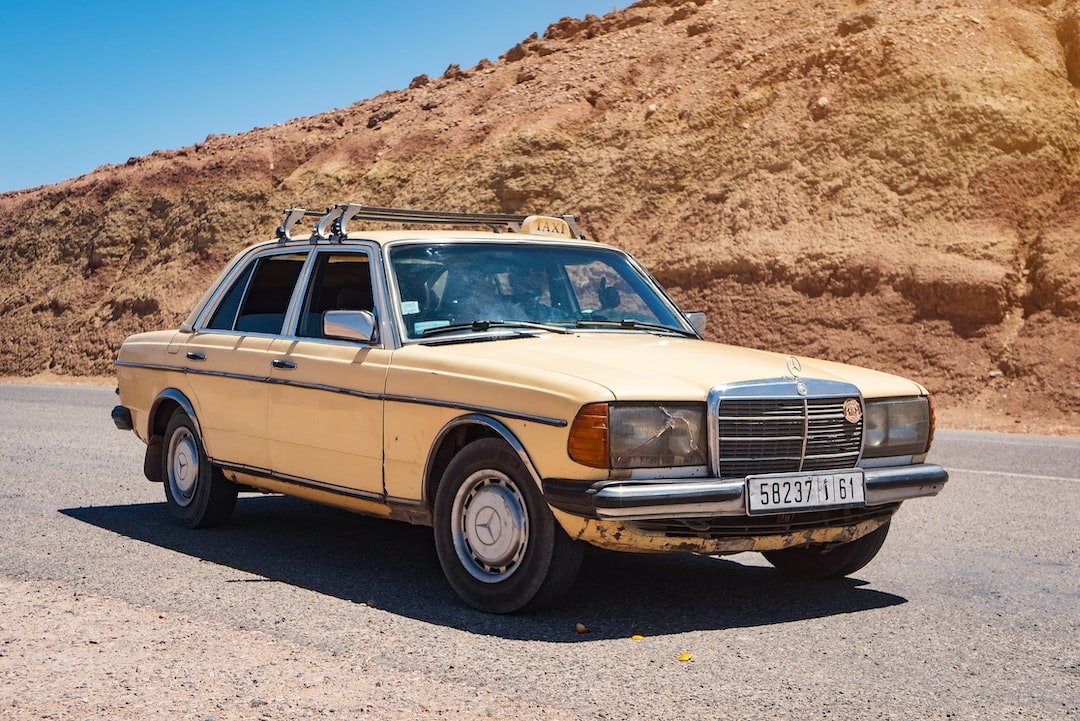 beige Mercedes-Benz sedan parked near mountain